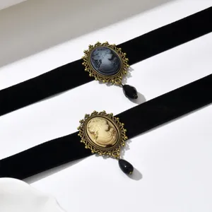 Vista piatta di due fasce in velluto nero, con cammei decorati e pendenti neri a forma di goccia