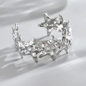 Bracciale aperto argentato con stelle in rilievo e superficie dalla texture martellata irregolare