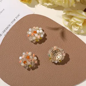 Three round bead clusters in ivory, orange and pink, one showing its perforated metal backing