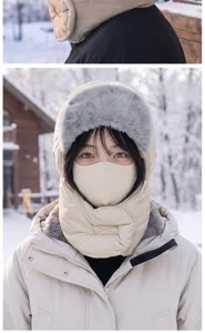 Primer plano de un cubrefaz invernal crema con borde de pelo sintético gris en la nieve.