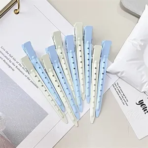 Flat lay of light blue and ivory perforated hair clips arranged in a fan on a pale surface