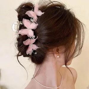 Close-up of pink mesh butterfly hair clips with pearl and rhinestone accents in an elegant updo