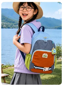 Sac à dos bleu-gris et orange, avec poche latérale verte et sangle poitrine, porté au bord d’un lac