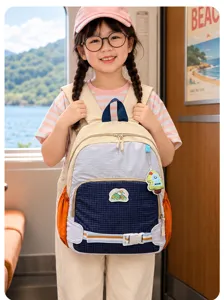 Un enfant porte un sac à dos coloré dans un train, avec un lac visible par la fenêtre