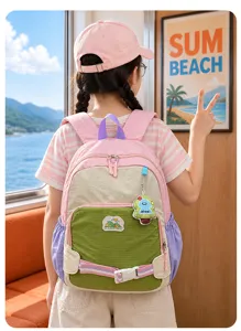Vue de dos d’un enfant portant un sac à dos coloré, avec boucle et breloque fantaisie