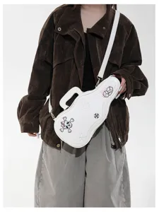 Sac blanc en forme de guitare sur veste brune, brodé de crâne, étoiles et trèfles
