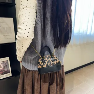 Petit sac porté en bandoulière, avec motif léopard, bordure noire et chaîne dorée visible