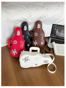 Quatre sacs en forme de guitare, rouges, noirs, bruns et blancs, avec motifs brodés et bandoulières