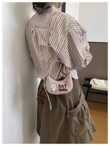 Sac bandoulière rose en peluche, porté à la taille, avec motif d’ours et texte SAY Hello