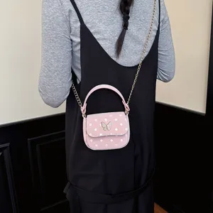 Petit sac rose en similicuir à pois, avec fermoir papillon et bandoulière chaîne dorée