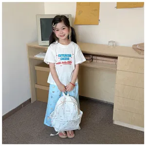 Un enfant porte un tee-shirt blanc et un pantalon bleu clair imprimé, avec un sac à dos blanc.