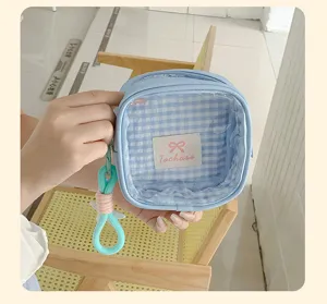 Vue rapprochée de l’intérieur à carreaux bleus, avec étiquette, fermeture zippée et boucle turquoise