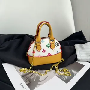 Sac coquillage à motifs colorés, bordure moutarde, anses hautes et chaîne dorée en bandoulière