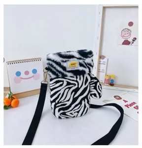 Petit sac zébré avec rabat en peluche, corps en maille et longue bandoulière noire réglable