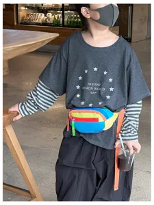 Un enfant porte une banane à panneaux arc-en-ciel, avec une sangle d'épaule orange vif