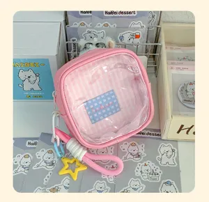 Gros plan sur une pochette rose avec fenêtre transparente, doublure à carreaux et étoile jaune