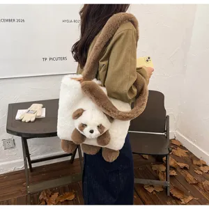 Sac en peluche blanc porté par un mannequin, avec bordure brune et pendentif panda suspendu.