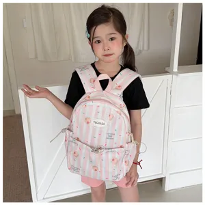 Enfant avec un sac rose rayé, imprimé de cupcakes et cerises, et doté de poches avant zippées