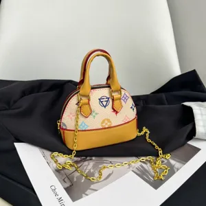 Détail d’un mini sac bombé à imprimé multicolore, bordure jaune et bandoulière chaîne dorée