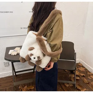 Sac porté en situation, en peluche blanche avec bandoulière brune et breloque ourson