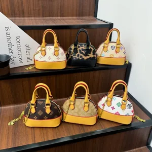Six petits sacs arrondis aux motifs variés, avec poignées jaunes, exposés sur des marches en bois.
