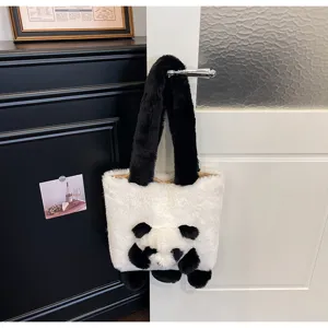 Sac blanc en peluche, visage de panda noir en relief et longues anses noires, suspendu à une porte