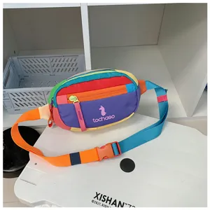 Sac multicolore avec zip frontal et sangle réglable orange et turquoise, posé sur une table blanche