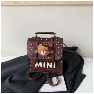 Détail du rabat brun à pois, avec peluche ours, broderie MINI et fermoir métallique