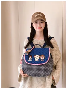 Sac à dos matelassé bleu, bord rouge et blanc, broderies de personnages et breloque ourson
