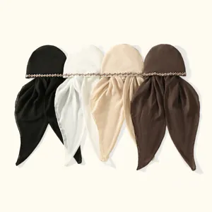 Quatre foulards drapés noirs, blancs, beiges et bruns, avec une bordure géométrique au sommet