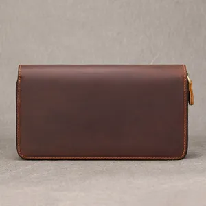 Front view of a dark brown leather wallet with textured surface, stitched edges and gold zipper pull