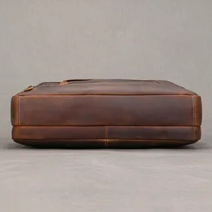 Vista laterale bassa di una borsa marrone in pelle, con cuciture visibili e base testurizzata