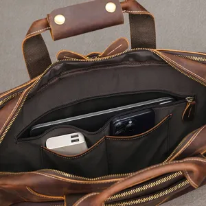 Primo piano dell’interno della borsa con scomparti, tasca con zip, tablet, telefono e caricatore