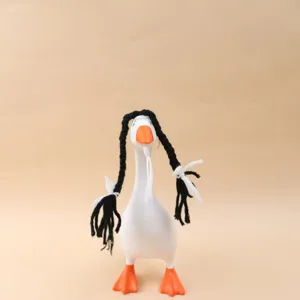 Oie décorative de table blanche, avec bec et pattes orange, tresses noires et nœuds en ruban blanc