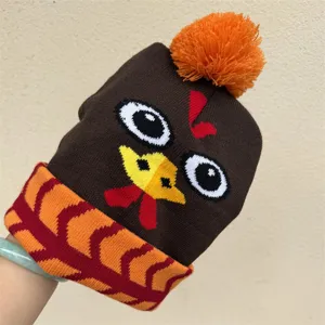 Bonnet tricoté brun à motif de dinde, pompon orange et bord replié à motif orange et rouge