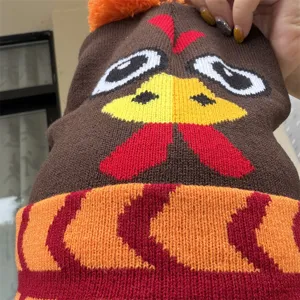 Bonnet tricoté de Thanksgiving avec visage de dinde, base brune, bord orange et pompon orange