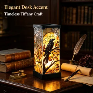 Stained-glass shade depicting a raven against an orange sunset, glowing on a vintage writing desk