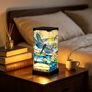 Illuminated stained-glass panels show a blue dragonfly, water lilies and leaves beside a bed