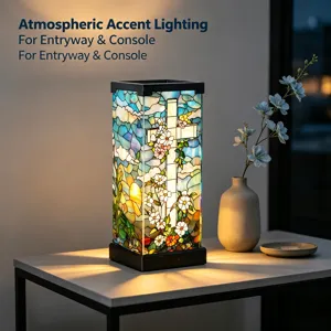 Glas-in-lood met bloemen en een kruis licht op in een zwart frame op een consoletafel