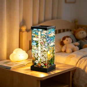 Vierkante kleurrijke glazen lamp met bloemenmotief en zwart metalen frame op een nachtkastje
