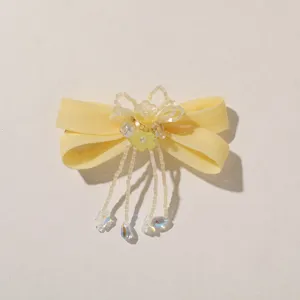 Yellow satin bow detail with pearl-like beads, tiny flowers and dangling clear drops