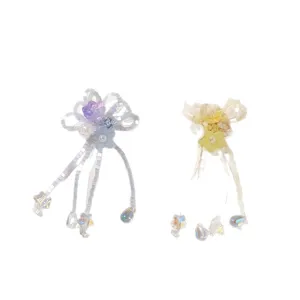 Pair of beaded lily flower accessories with dangling star charms, in purple-blue and yellow-white