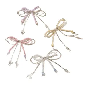 Quattro charm a forma di fiocco con perline, lilla, crema, rosa e bianco, con filo color argento