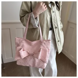 Borsa tote rosa con stelle argentate e grande fiocco, portata a mano dai lunghi manici