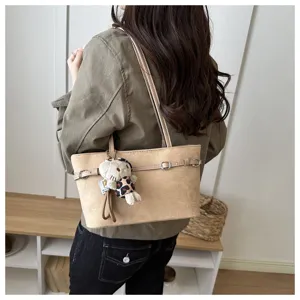 Borsa beige opaca effetto camoscio portata a spalla, con fibbie decorative e un orsetto maculato