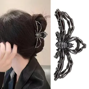 Dettaglio della molletta a ragno nera lucida su uno chignon, con il modello metallico su fondo bianco