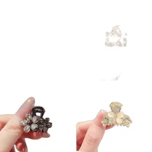 Mini flower claw hair clips with rhinestone and pearl petals, shown in dark and gold finishes