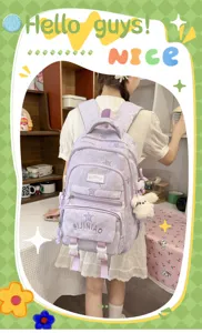 Vue arrière d’une élève avec un sac lilas à poches avant et un pendentif lapin en peluche