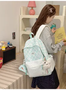 Vue arrière d’un sac à dos vert clair à carreaux et pois, avec pochette assortie et charm en peluche