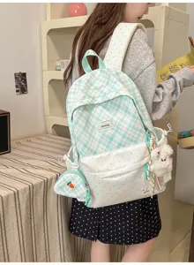 Vue de dos d'un sac à carreaux menthe, avec poches à pois, pochette carotte et breloque en peluche